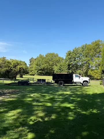 Tree service equipment staged on a wide residential property before work begins.