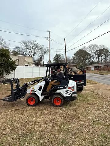 Compact equipment helps move heavy wood while protecting the surrounding property.